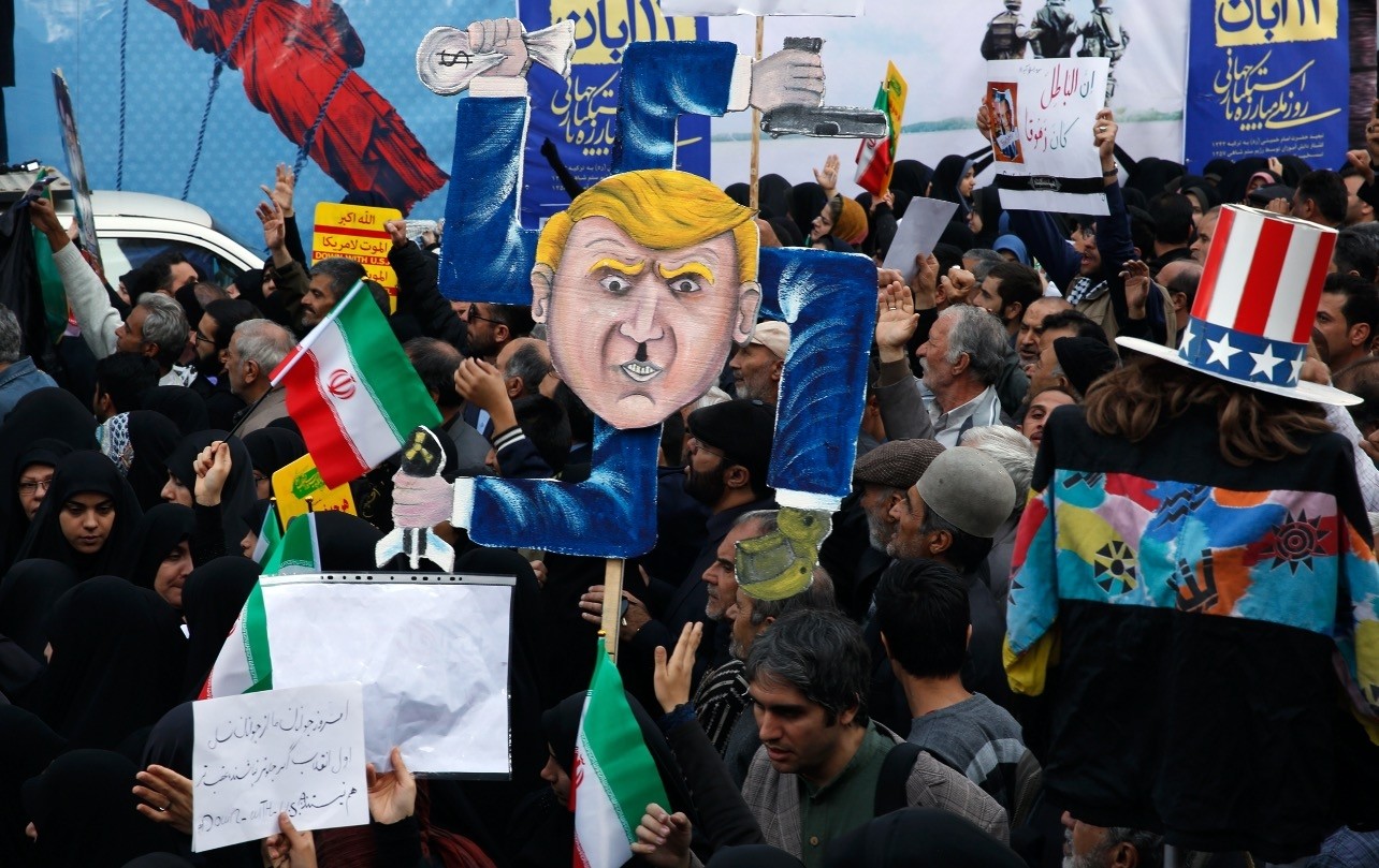 Iranians hold a placard showing a caricature of U.S. President Donald Trump during an anti-U.S. demonstration marking the 39th anniversary of U.S. Embassy takeover, in front of the former U.S. Embassy in Tehran, Iran, Nov. 4.