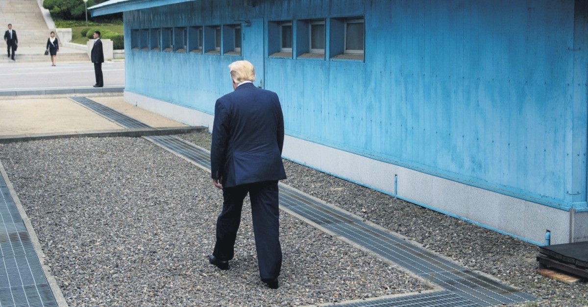 U.S. President Donald Trump walks to the line of demarcation to meet North Korea's leader Kim Jong Un in the Demilitarized Zone (DMZ), June 30, 2019.