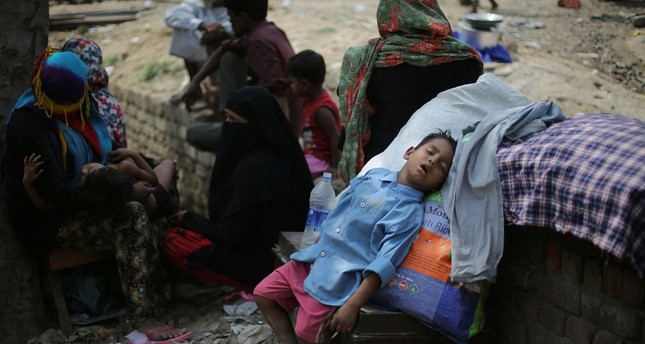 A boy naps under the shade of a tree after an early Sunday fire razed down a Rohingya camp in the Kalindi Kunj area of New Delhi, April 15.