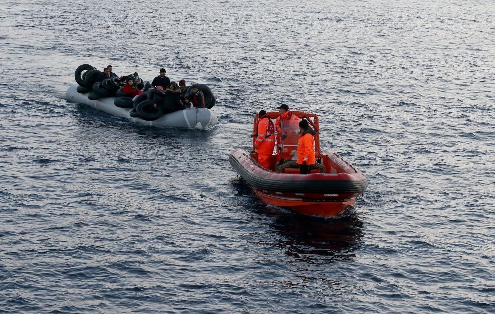 A Turkish Coast Guard boat tows a boat carrying migrants off the coast of u00c7eu015fme, a district of u0130zmir, in this undated photo.