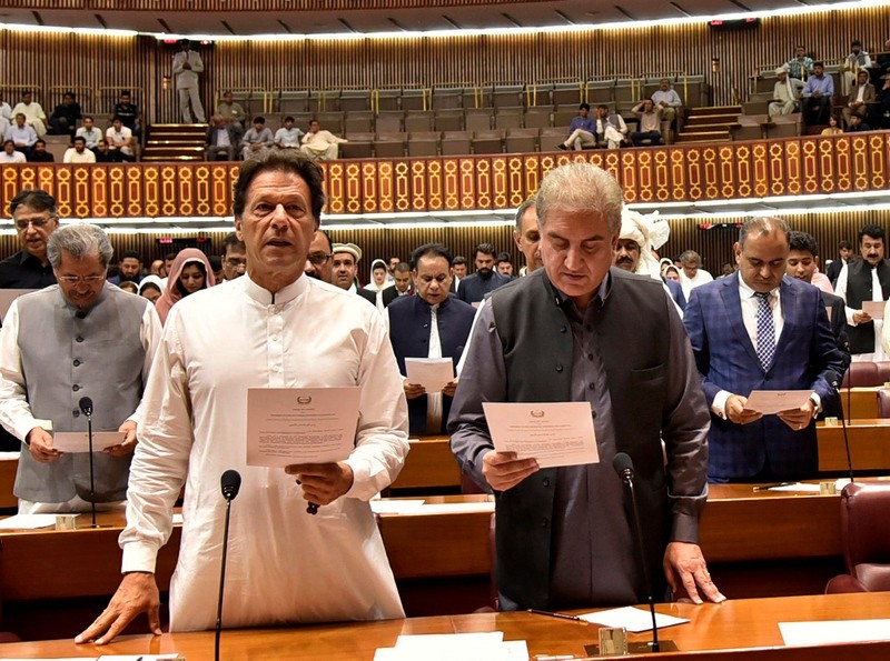 In this photo released by the National Assembly, newly elected parliamentarian Imran Khan, left, takes the oath of office with Shah Mehmood Qureshi, in Islamabad, Pakistan, Monday, Aug. 13, 2018. (AP Photo)