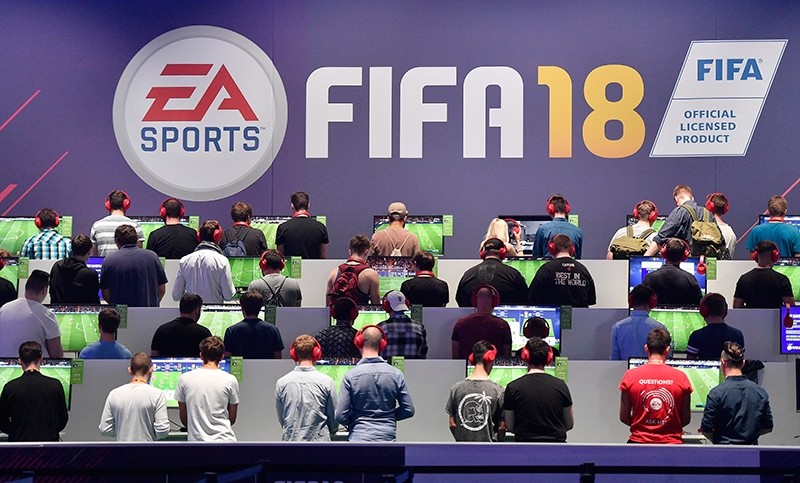 Visitors play the latest FIFA 18 soccer game from EA Sports at the Gamescom fair for computer games in Cologne, Germany, Aug. 22, 2017. (AP Photo)