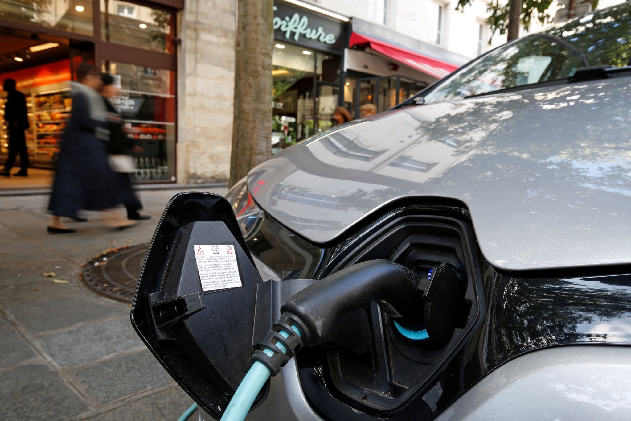 An electric car being charged in a Paris street.