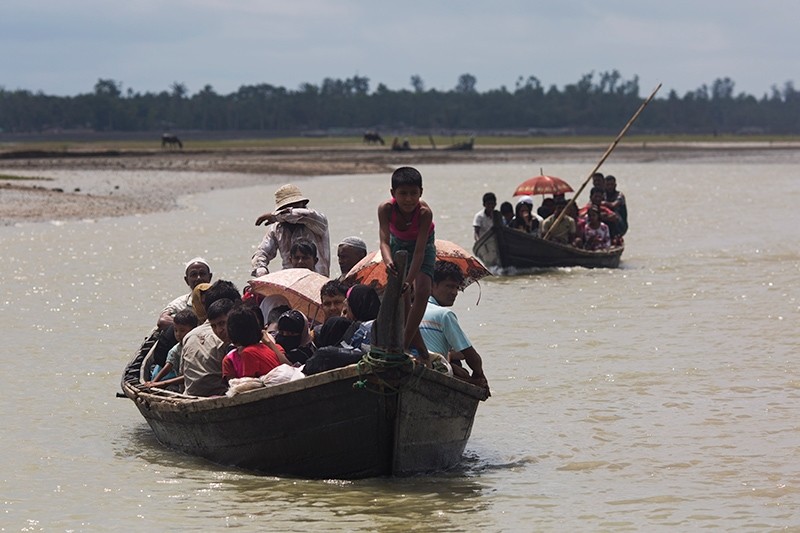 Myanmar's Rohingya Muslim minority use a local boat to cross a stream after crossing over to the Bangladesh side of the border near Cox's Bazar's Dakhinpara area, Sept. 2, 2017. (AP Photo)