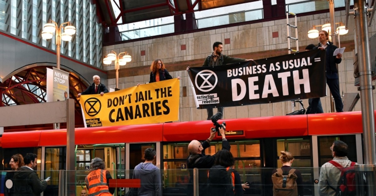 Demonstrators stand on top of a DLR train as they block the traffic at Canary Wharf Station, during the Extinction Rebellion protest in London, Britain April 25, 2019. (REUTERS Photo)