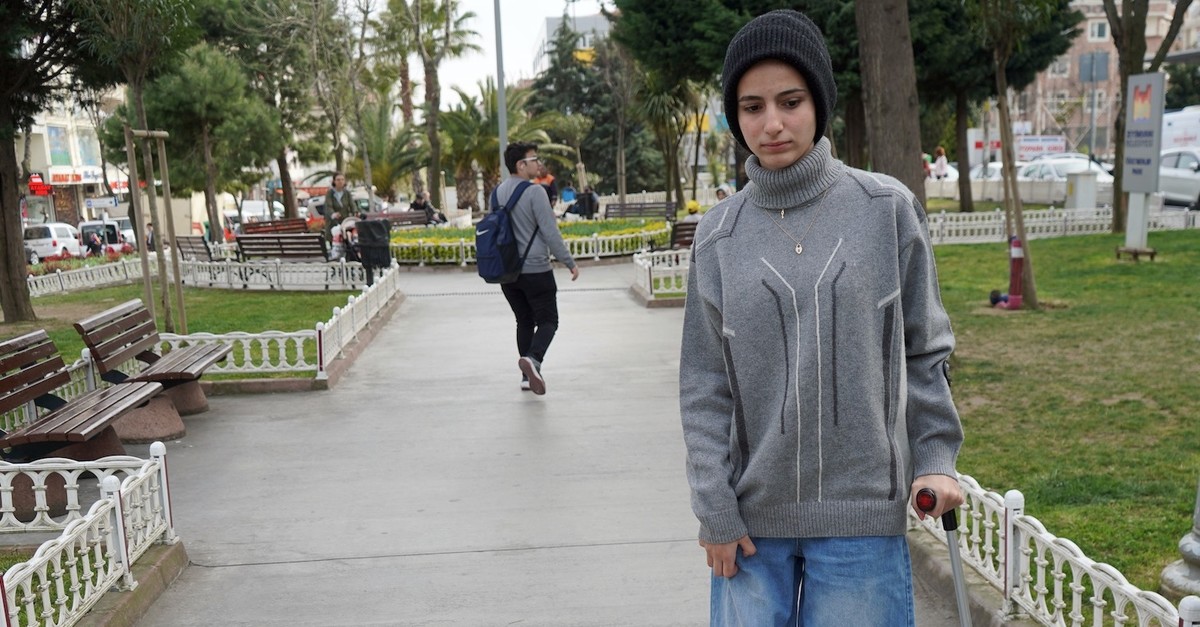 Meryem Abu-Matar walks with the help of a walking stick in a park in Istanbul, April 4, 2019.