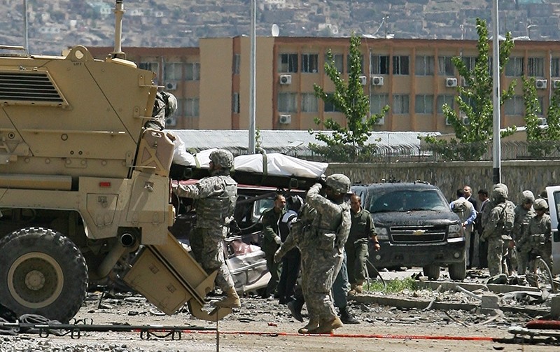 In this May 18, 2010 file photo, U.S. soldiers load dead bodies on a vehicle after a suicide attack in Kabul, Afghanistan. (AP Photo)