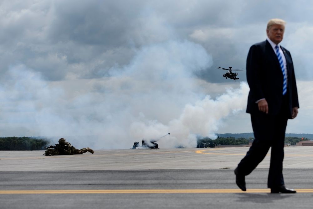 U.S. President Donald Trump walks as a canon fires in the background during an air assault exercise at Fort Drum Aug. 13, 2018 in New York.