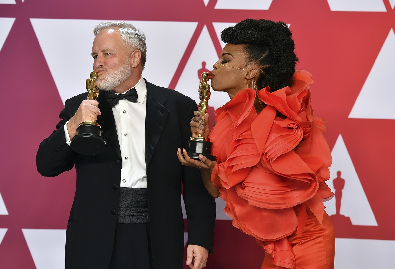 Jay Hart, left, and Hannah Beachler kiss their awards for best production design for 