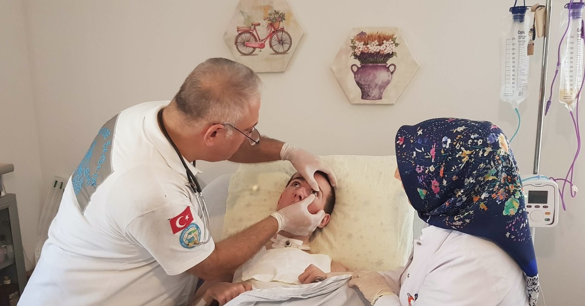 Doctors examine Tufan Au015fu00e7u0131 at his home in Istanbul.