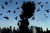 An Indian Muslim flute seller plays one of his wares to attract buyers in Bombay, April 18, 2002. 
