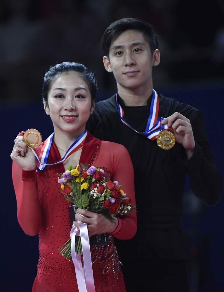 Sui Wenjing (L) and Han Cong (R) of China show their medals after winning the pairs free skating event at the Cup of China ISU Grand Prix of Figure Skating in Beijing.