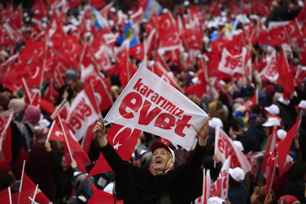 A supporter of the 'yes' campaign waving a banner, reading ,'Kararu0131mu0131z evet' which is translated in English as 'Our decision is Yes', referring to the April referendum, during a rally in the northern city of Rize, April 3.
