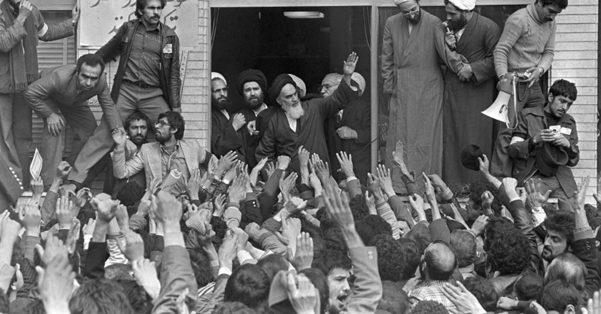In this Feb. 1, 1979 file photo, Ayatollah Ruhollah Khomeini, center, waves to followers as he appears on the balcony of his headquarters in Tehran, Iran.  