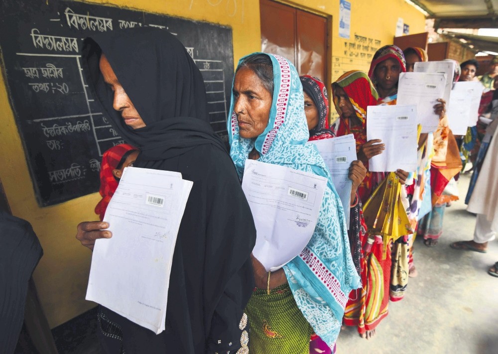 Residents hold their documents as they stand in a queue to check their names on the final list of National Register of Citizens (NRC) at a NRC Sewa Kendra (NSK) in Burgoan village in Morigoan district on Monday. (AFP Photo)