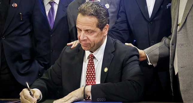 FILE - In this April 10, 2017, file photo, New York Gov. Andrew Cuomo signs new legislation for free state college tuition and juvenile justice reform, during a signing ceremony in New York (AP Photo)