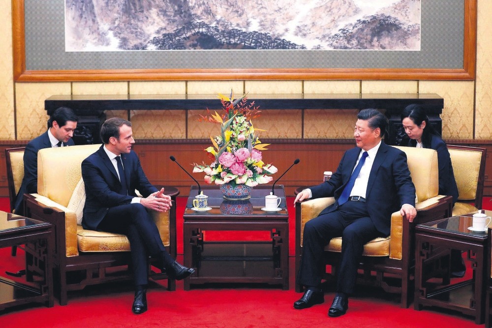 French President Emmanuel Macron (L) chats with Chinese President Xi Jinping during a meeting at the Diaoyutai State Guesthouse, Beijing,  Jan. 8.