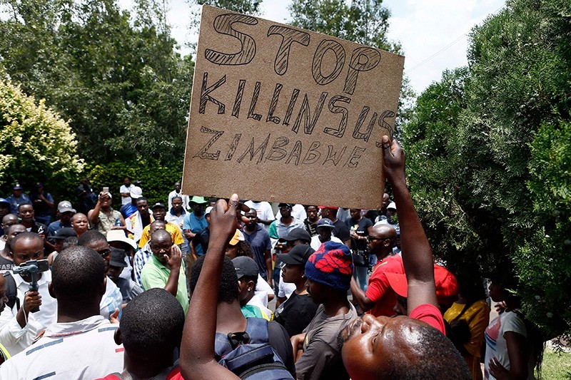 A protester holds a placard during a demonstration of Zimbabwean citizens outside the Zimbabwean Embassy in Pretoria  on Jan. 16, 2019. (AFP Photo)