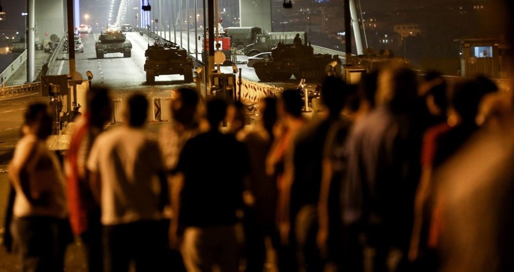 An anti-coup crowd looks at tanks and putschist soldiers on an Istanbul bridge where 34 people were killed on July 15, 2016.