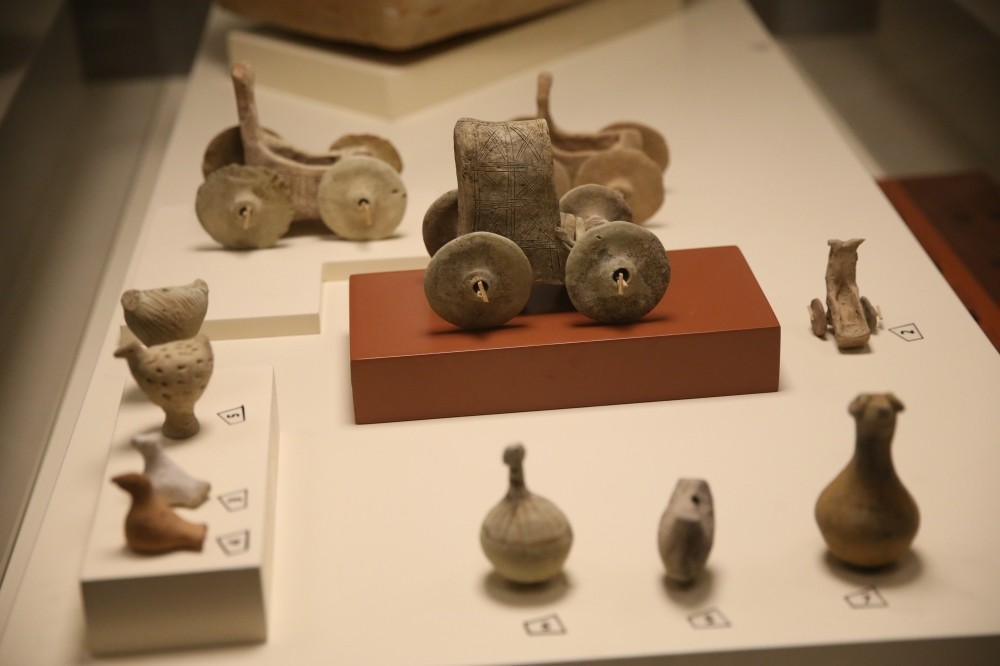 The toy chariot (above) and a rattle are among the artifacts discovered in child's grave.