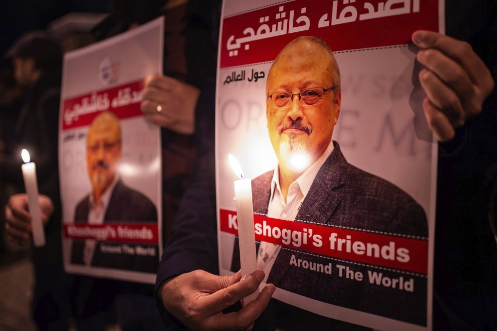 People hold posters of Saudi journalist Jamal Khashoggi and light candles during a gathering outside the Saudi Consulate in Istanbul, Oct. 25.