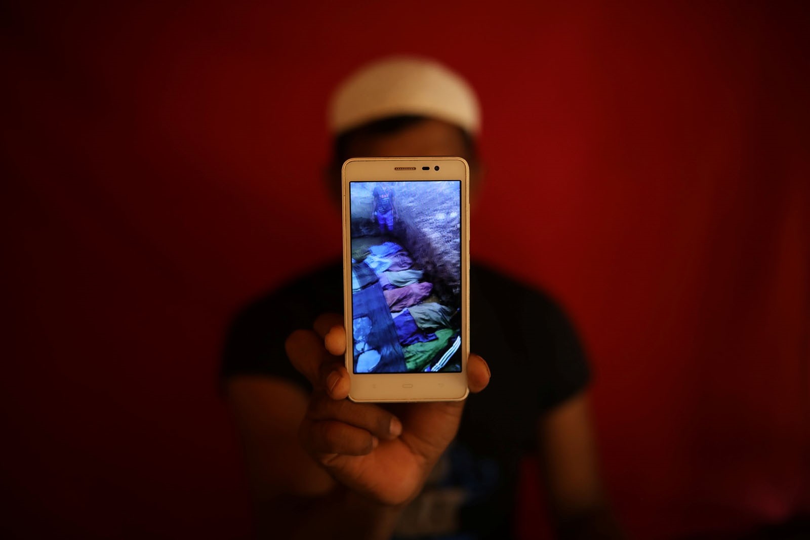 Islamic teacher Mohammed Younus holds a mobile phone on May 20, 2018 showing a video of what he says are the bodies of Rohingya Muslims killed by government forces in Kyauk Pan Du, Myanmar, on August 28, 2017.