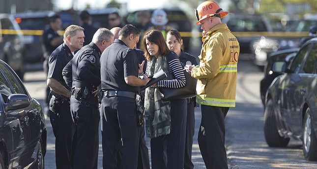 Los Angeles Fire department's Erik Scott, far right, police officers and school officials gather outside the Belmont Middle School in Los Angeles Thursday, Feb. 1, 2018 (AP Photo)