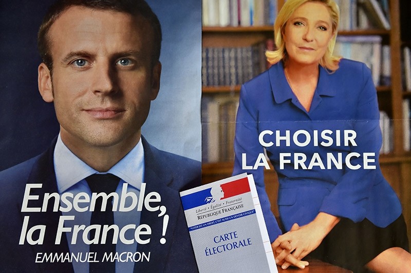 A picture taken on May 4, 2017 shows a voter ID displayed on top of campaign flyers of French presidential candidates Emmanuel Macron and Marine Le Pen in Nantes on May 4, 2017 ahead of the 2nd round of the presidential election on May 7. (AFP Photo)