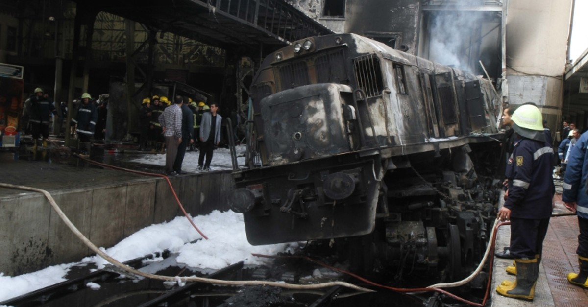 Fire fighters and onlookers gather at the scene of a fiery train crash at the Egyptian capital Cairo's main railway station on February 27, 2019. (AFP Photo)