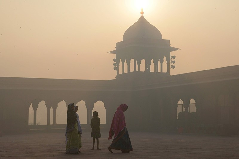 Indian women walk as smog envelops the Jama Masjid mosque in the old quarters of New Delhi, India. (AFP File Photo)