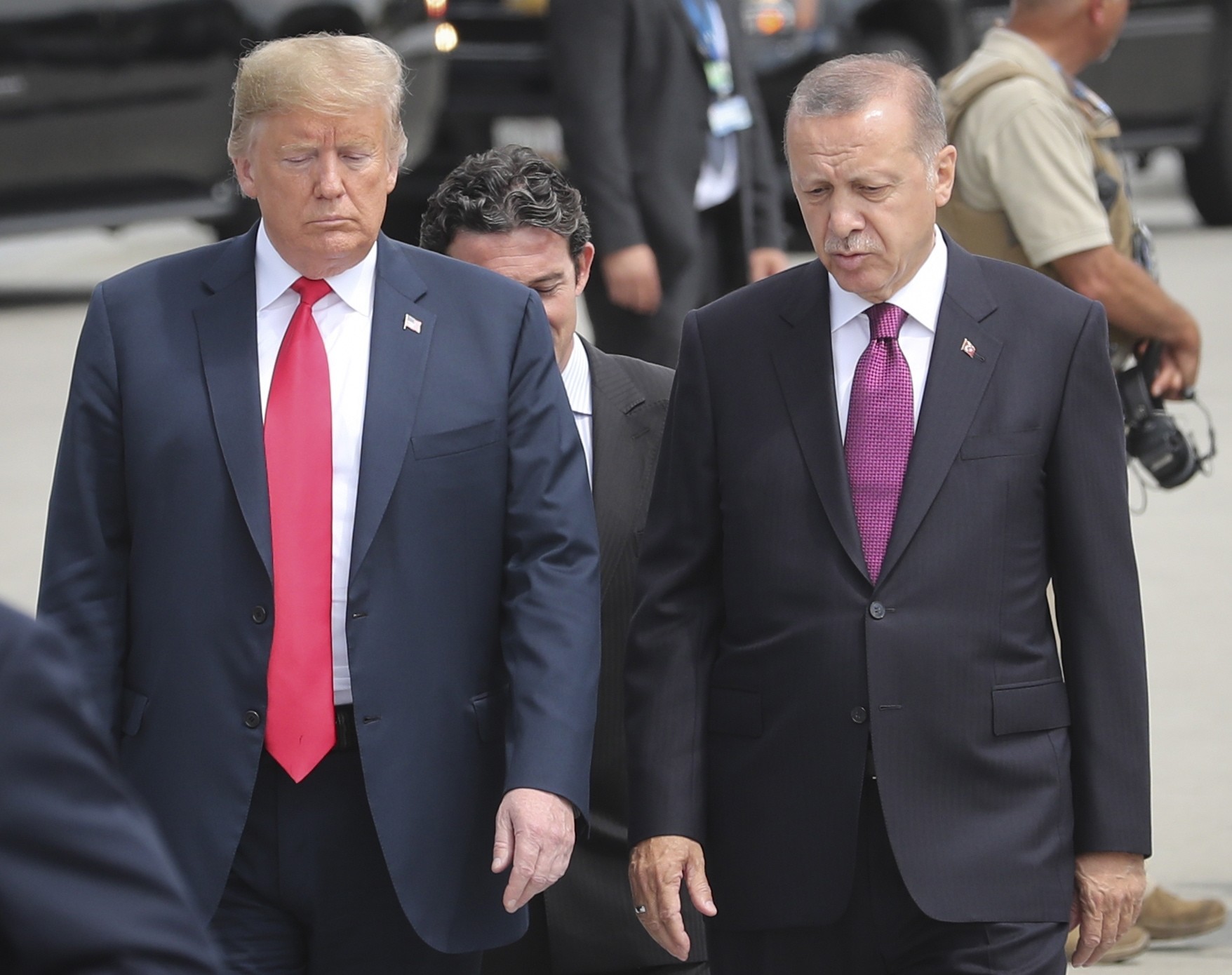 U.S. President Donald Trump (L) and President Recep Tayyip Erdou011fan (R) talk while walking to attend NATO's Brussels Summit, Belgium, July 11.