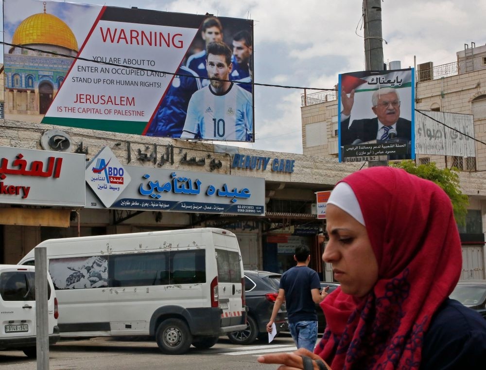 Poster erected on a main street in the West Bank town of Hebron denounces the planned friendly football match between Argentina and Israel and calls Argentina's star Lionel Messi (portrait) to boycott the match.