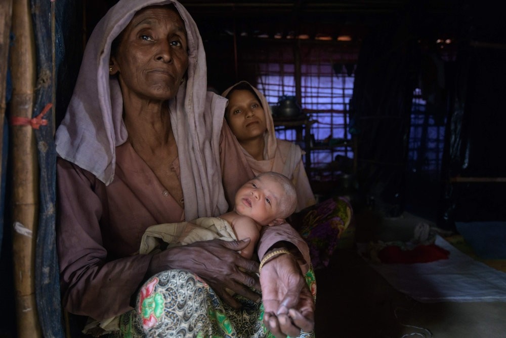 A Rohingya refugee sits behind her eight-day-old baby and her mother-in-law at the Thangkhali refugee camp near Cox's Bazar, Aug. 11, 2018.