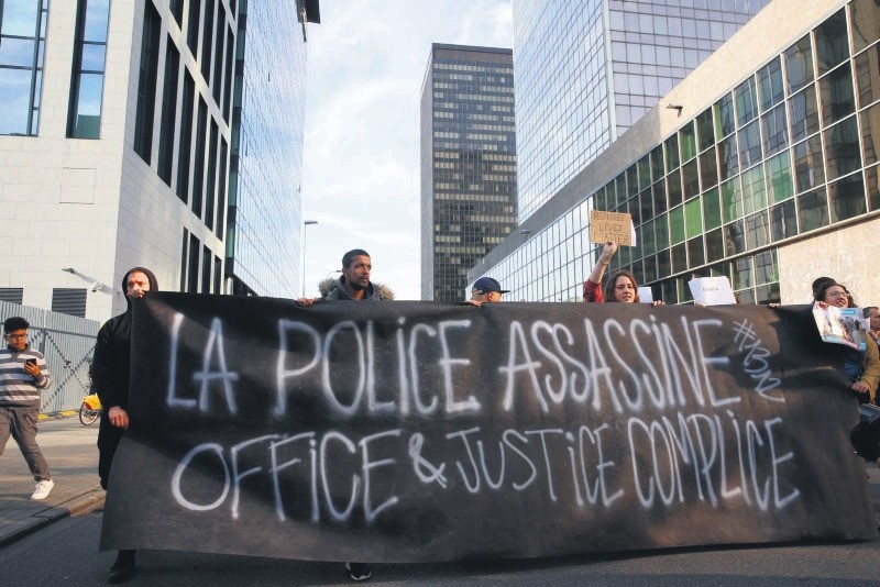 Members of several associations for the defense of asylum seekers' rights attend a protest in front of the immigration office in Brussels after a three-year-old girl died during a chase with police, May 18.