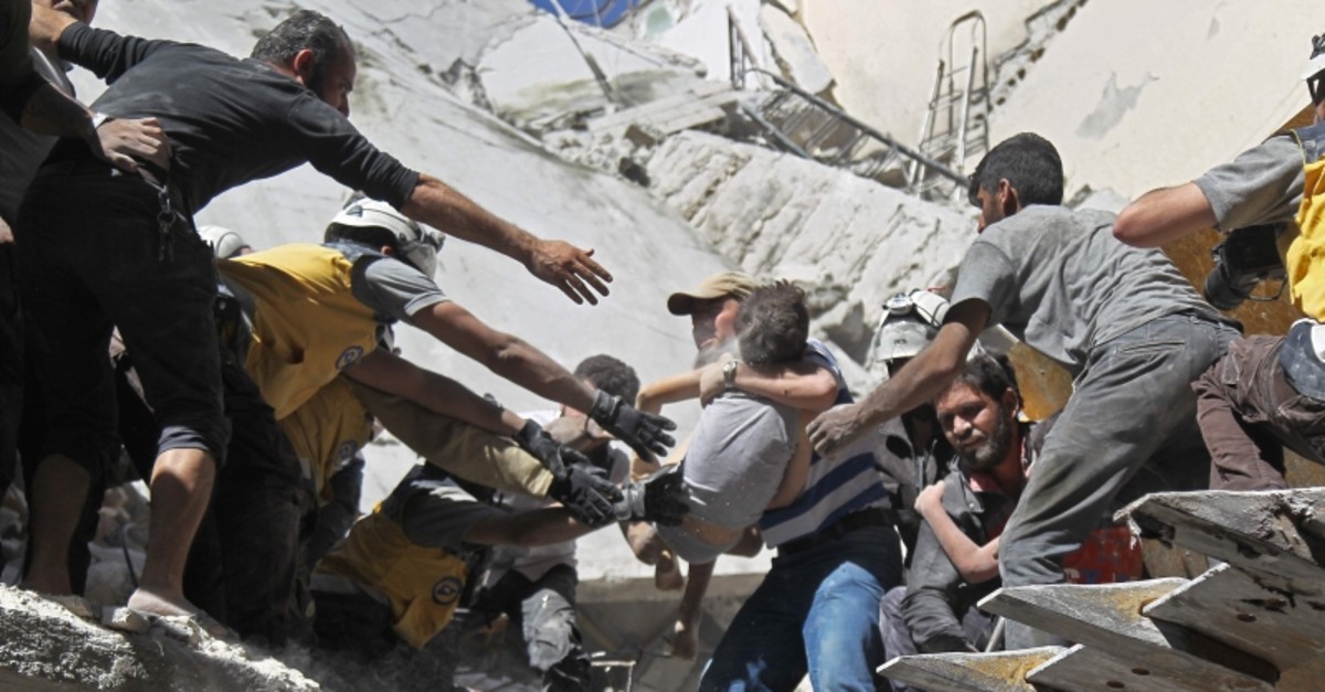 White Helmet volunteers and civilians rescue a child from the rubble of a building destroyed during an airstrike by the Assad regime forces and their allies in Ariha, southern Idlib province, Syria, May 27, 2019. (AFP Photo)