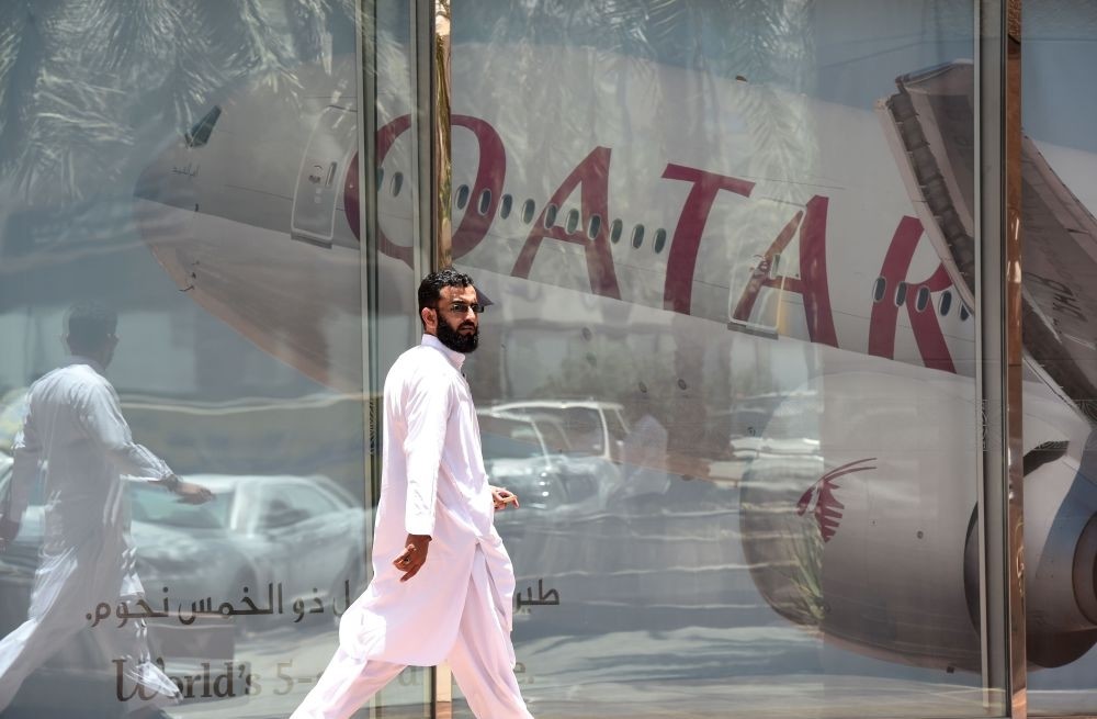 A picture taken Monday shows a man walking past a Qatar Airways branch in the Saudi capital Riyadh, after it had suspended all flights to Saudi Arabia following a severing of relations between major gulf states and gas-rich Qatar.