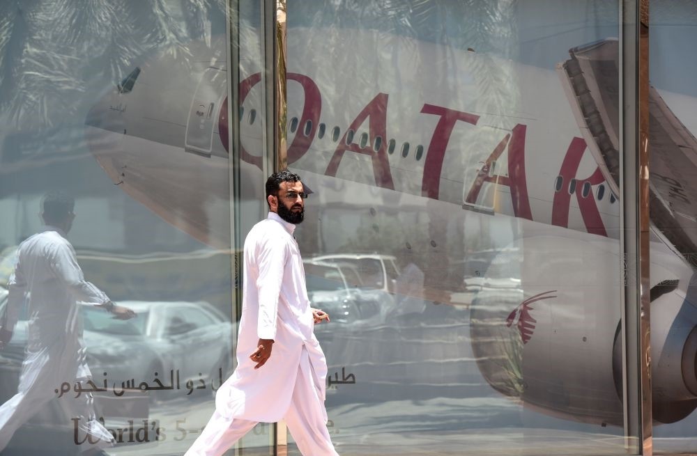 A picture taken Monday shows a man walking past a Qatar Airways branch in the Saudi capital Riyadh, after it had suspended all flights to Saudi Arabia following a severing of relations between major gulf states and gas-rich Qatar.