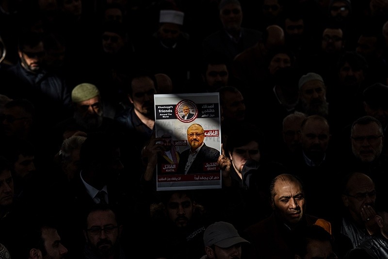 In this Nov. 16, 2018 photo, a person holds a banner of Jamal Khashoggi during a symbolic funeral prayer for the Saudi journalist, killed and dismembered in the Saudi consulate in Istanbul in October, at the courtyard of Fatih mosque. (AFP Photo)