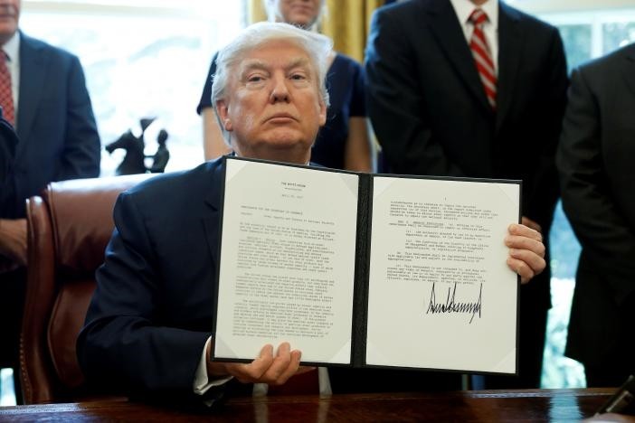 U.S. President Donald Trump holds up a directive ordering an investigation into the impact of foreign steel on the American economy after signing it in the Oval Office of the White House in Washington, U.S., April 20, 2017. (Reuters Photo)