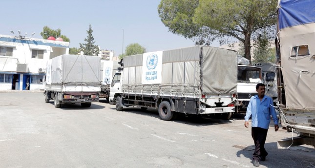 شاحنات الإغاثة الإنسانية متوفقة عند مدخل بلدة يلدا، جنوب دمشق EPA