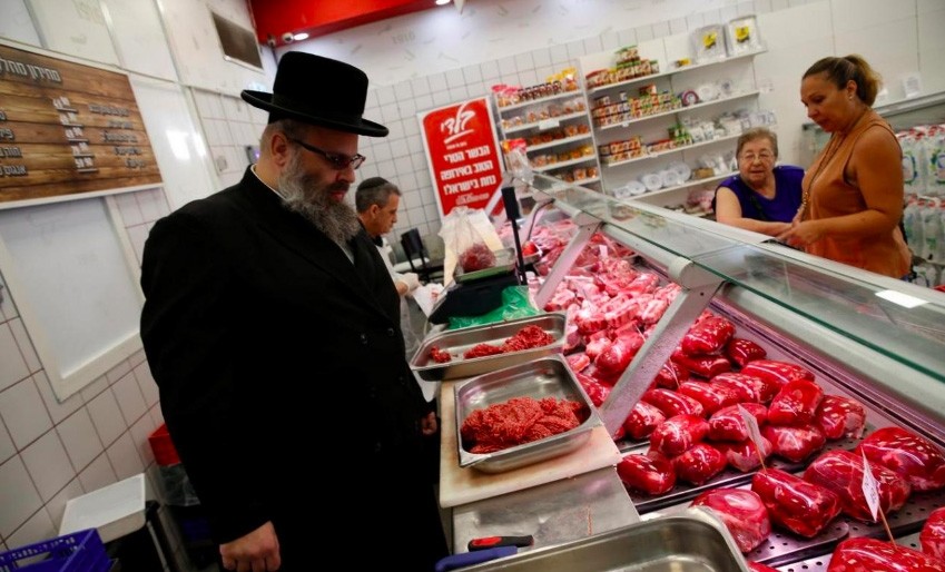 Kosher inspector Aaron Wulkan examines display refrigerators containing meat in a food store to ensure that the food is stored and prepared according to Jewish regulations and customs (Reuters File Photo)