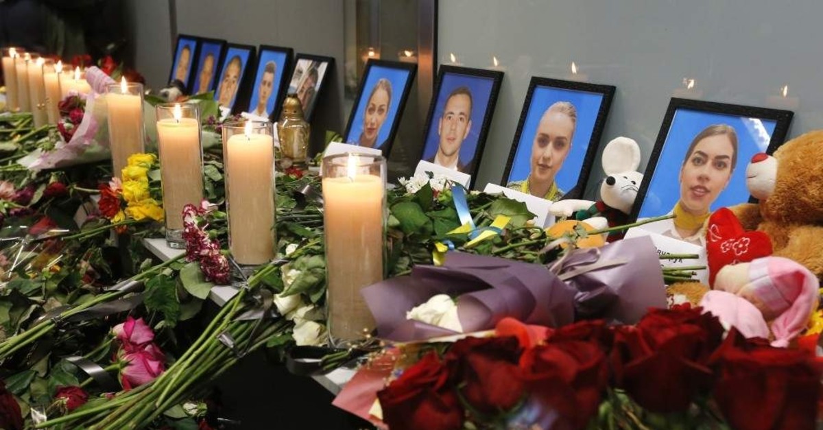 Flowers and candles are placed in front of portraits of the flight crew members of the Ukrainian 737-800 plane that crashed on the outskirts of Tehran, at a memorial inside Borispil International Airport outside Kyiv, Ukraine, Saturday, Jan. 11, 2020. (AP Photo)
