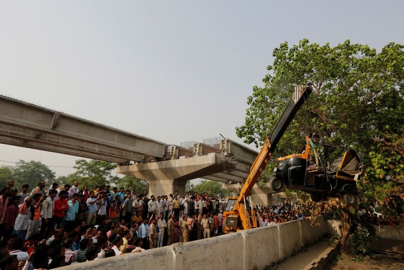 A crane is used to lift an auto rickshaw that got crushed after a highway overpass being built collapsed in Varanasi, India, Wednesday, May 16, 2018 (AP Photo)