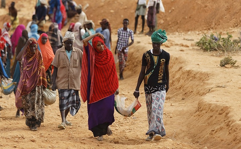 In this photo taken March 8, 2017, women and men carry away earth after digging to build a dam so that if rains do come the water can be stored near Bandar Beyla in Somalia's semiautonomous northeastern state of Puntland. (AP Photo)
