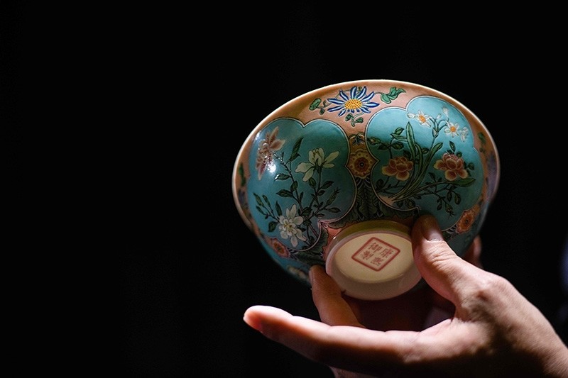 Nicolas Chow, deputy chairman for Sotheby's Asia, holds an extremely rare Qing Dynasty bowl  (AFP Photo)