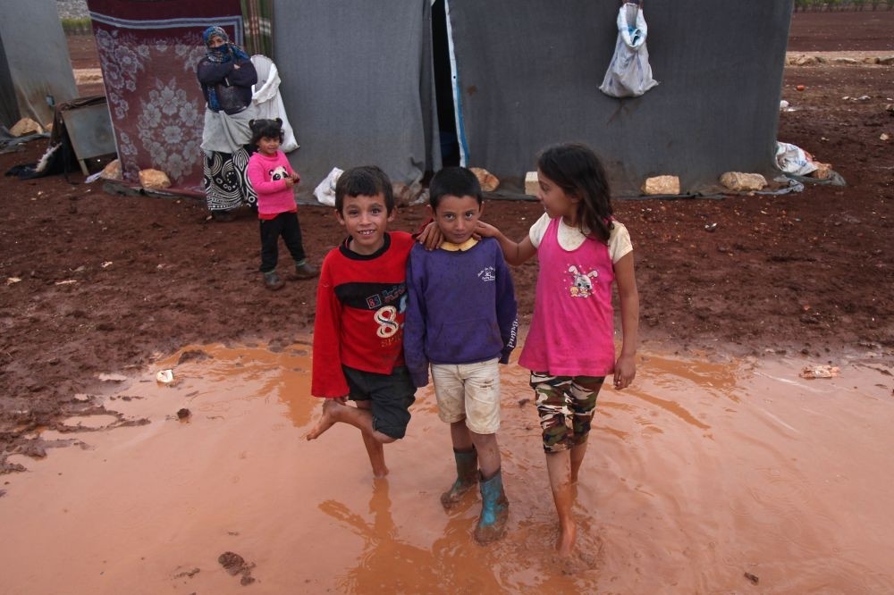 Internally displaced Syrian children pose for a photograph in a flooded refugee camp in the Idlib countryside, northwestern Syria, Oct. 25.