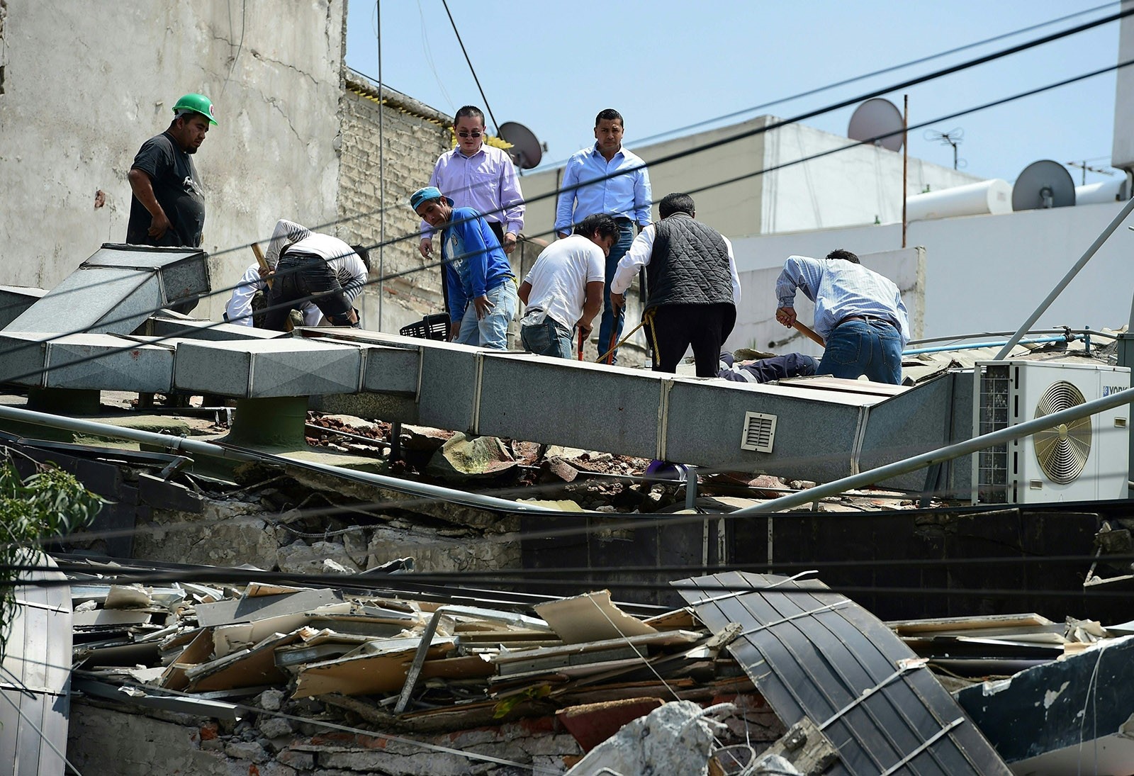 People look through debris of a building which collapsed when  quake rattled Mexico City on September 19, 2017. (AFP Photo)