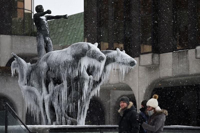 People walk past a statue of horses that is frozen over in the city center of Dublin, Ireland, March 1, 2018. (Reuters Photo)
