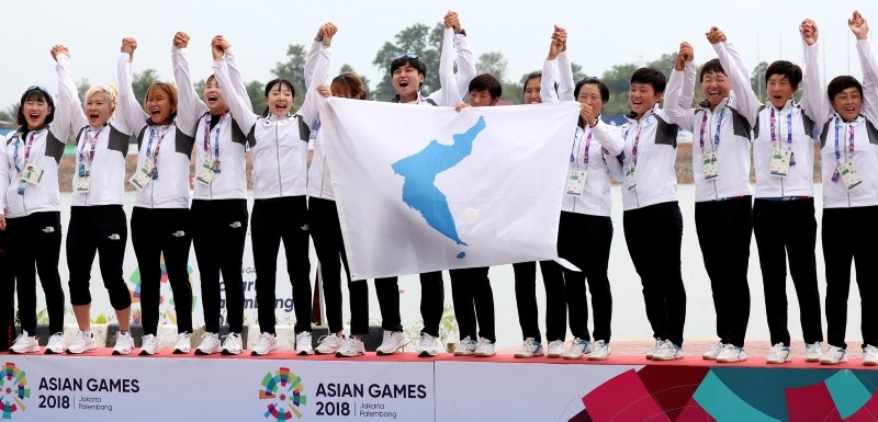 Members of combined Koreas team celebrate their victory during the ceremony for women's 500-meter dragon boat at the 18th Asian Games in Palembang, Indonesia, Sunday, Aug. 26, 2018. (Kim Do-hun/Yonhap via AP)