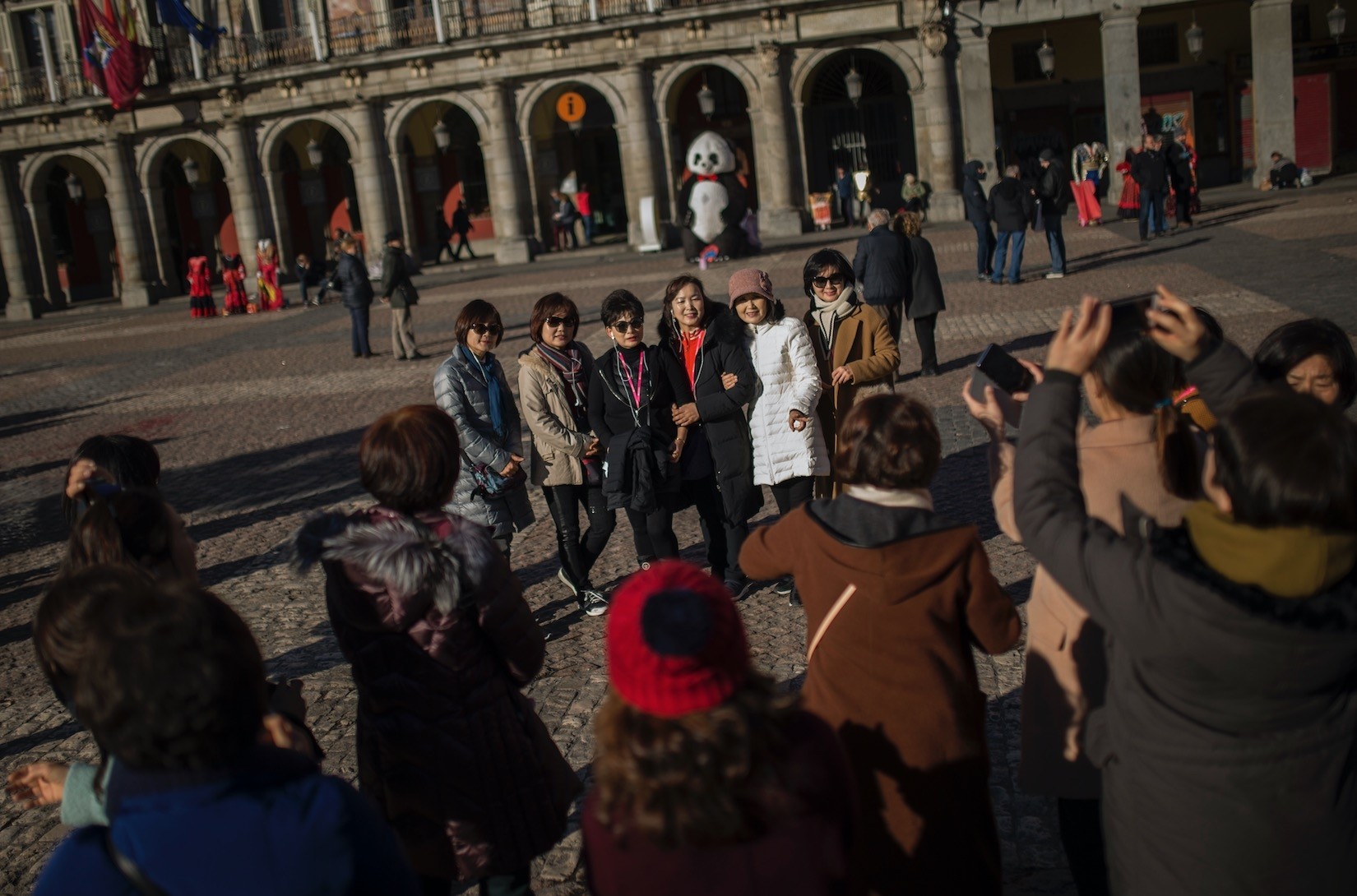 Tourists pose for a photograph at Mayor square in central Madrid. Spain says it has broken its record of international visitors for the fifth consecutive year in 2017 with 82 mn tourists that chose restive Catalonia as their main Spanish destination.